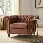 Poltrona Chesterfield Zeus e Ruta con braccioli arrotolati, finiture con borchie e gambe in legno massello